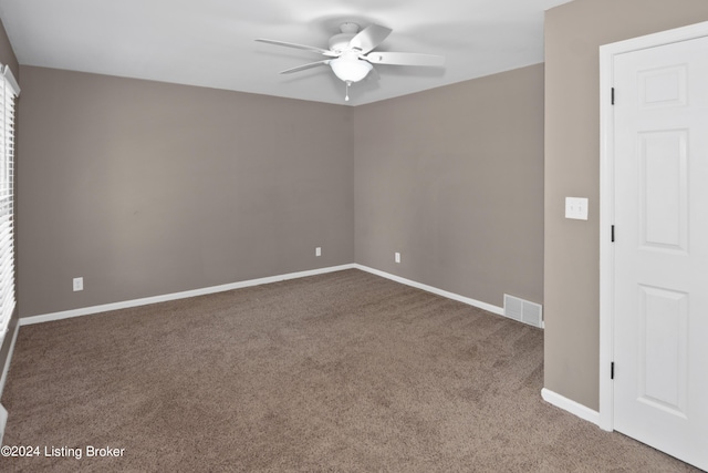 carpeted spare room featuring ceiling fan