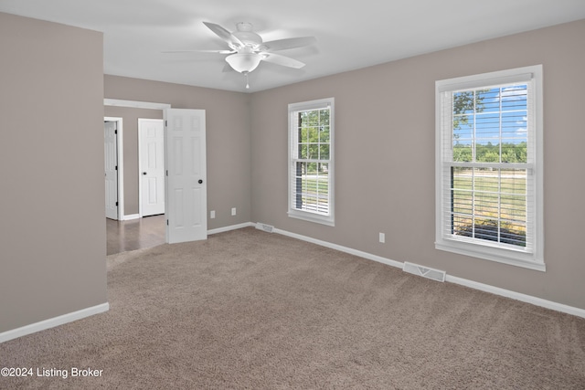 unfurnished room featuring carpet, a healthy amount of sunlight, and ceiling fan