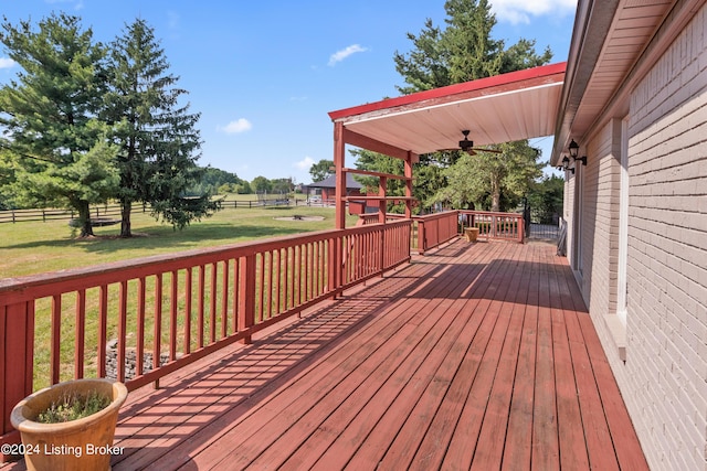 wooden terrace featuring a yard and ceiling fan