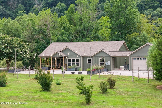 view of front of property featuring a garage, a front lawn, and central air condition unit