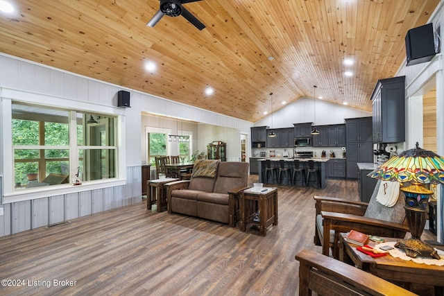 living room with ceiling fan, high vaulted ceiling, dark hardwood / wood-style flooring, wooden ceiling, and wood walls