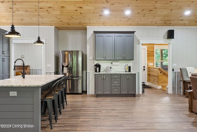 kitchen featuring pendant lighting, stainless steel fridge, and gray cabinetry