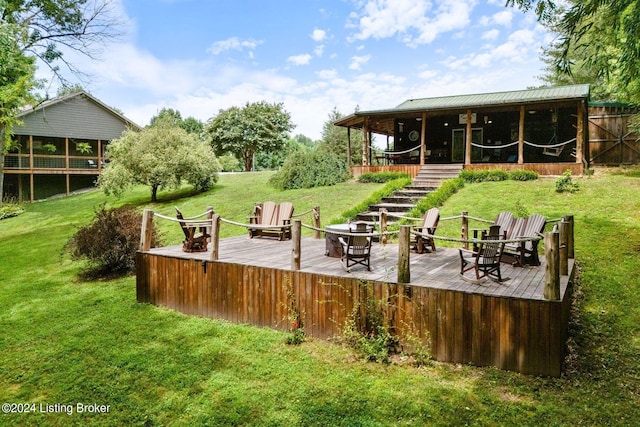 deck with a yard and a fire pit