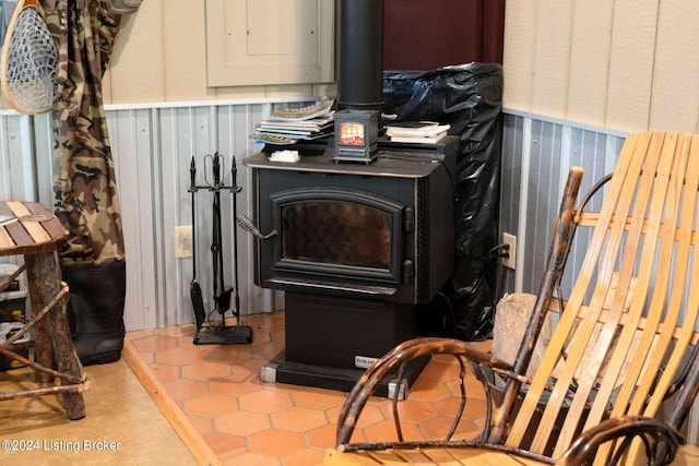 interior details with a wood stove and electric panel