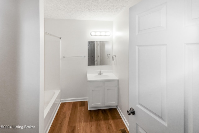 bathroom with vanity, a textured ceiling, and hardwood / wood-style flooring