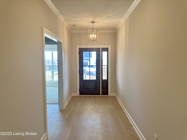 doorway to outside with ornamental molding, an inviting chandelier, and light hardwood / wood-style flooring