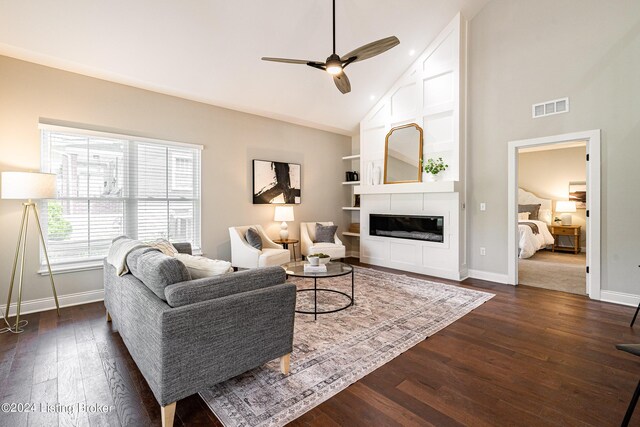 living area with a large fireplace, visible vents, dark wood finished floors, and baseboards