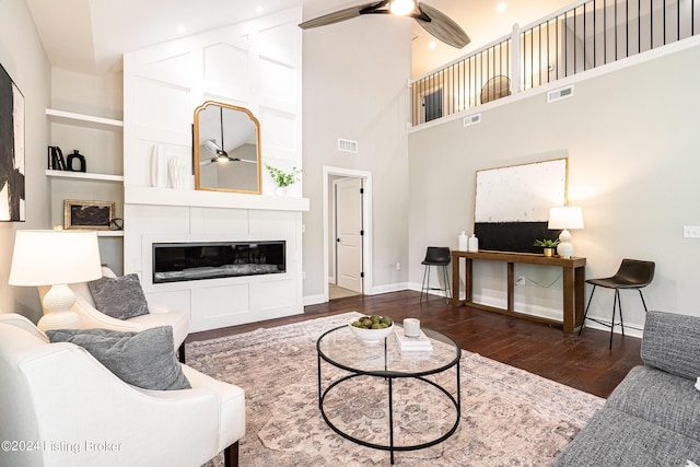 living area with visible vents, ceiling fan, and wood finished floors