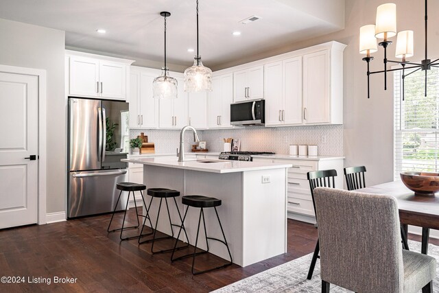 kitchen featuring tasteful backsplash, visible vents, appliances with stainless steel finishes, light countertops, and a sink