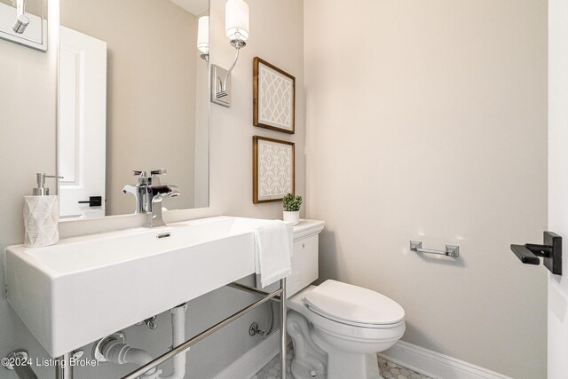 bathroom featuring baseboards, vanity, and toilet