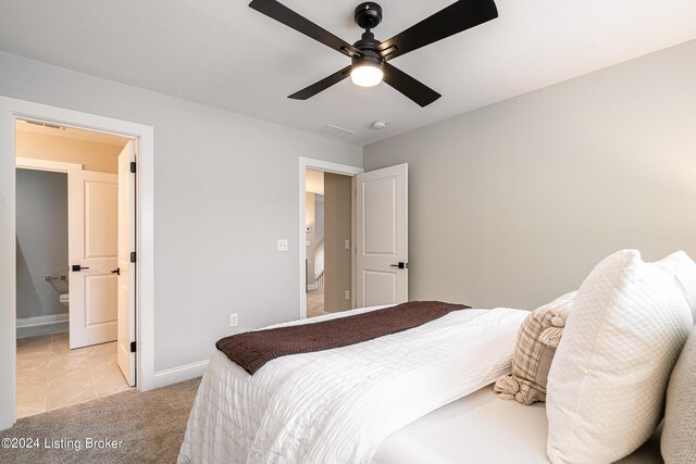 bedroom with connected bathroom, light colored carpet, a ceiling fan, baseboards, and visible vents