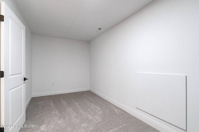 carpeted empty room featuring visible vents and baseboards