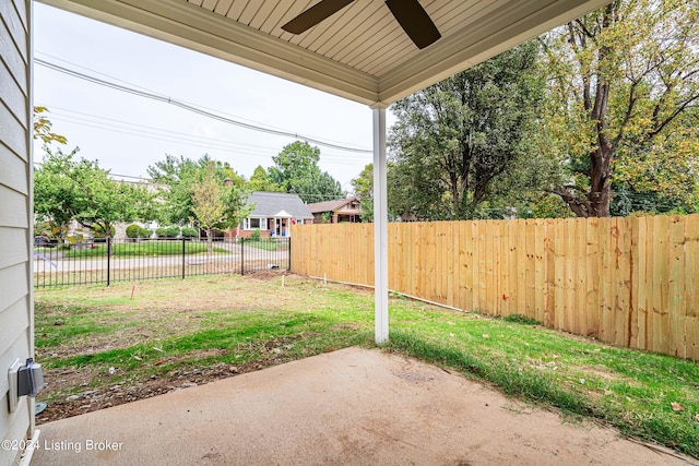 view of yard featuring fence, a ceiling fan, and a patio