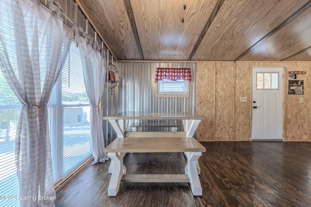 dining space featuring plenty of natural light, wooden ceiling, and wood walls