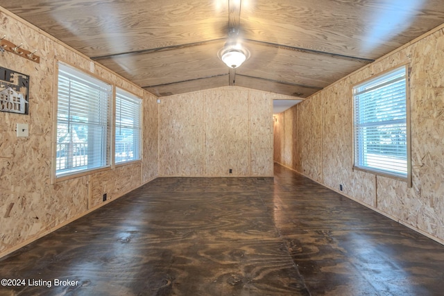 unfurnished living room with wooden ceiling and wood walls