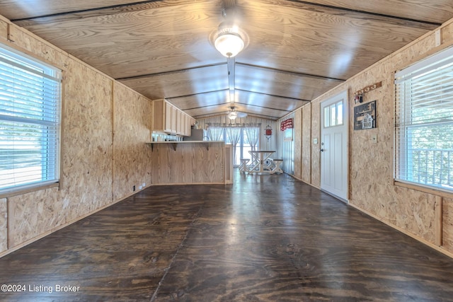 interior space with lofted ceiling, dark hardwood / wood-style flooring, wooden ceiling, and wood walls