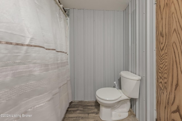 bathroom featuring hardwood / wood-style floors, toilet, and wood walls