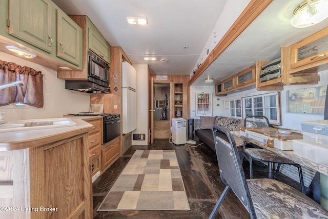 kitchen featuring black microwave, sink, dark hardwood / wood-style flooring, and green cabinetry