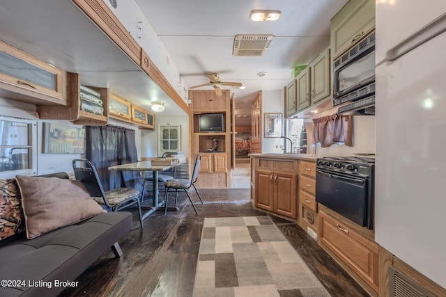 kitchen featuring sink, dark hardwood / wood-style floors, ceiling fan, and white refrigerator