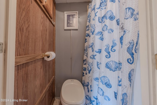 bathroom with a shower with curtain and toilet