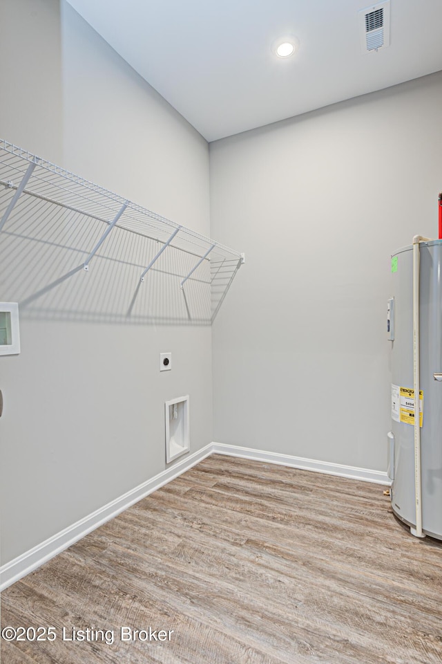 laundry area with water heater, electric dryer hookup, hookup for a washing machine, and light wood-type flooring