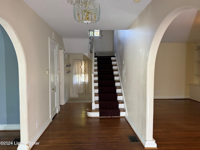 hallway featuring a notable chandelier and dark hardwood / wood-style flooring