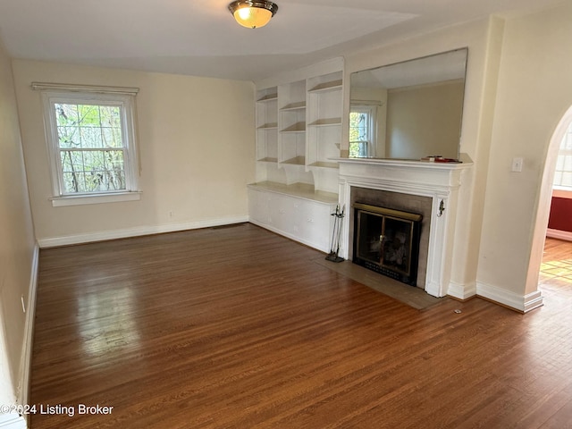 unfurnished living room featuring dark wood-type flooring