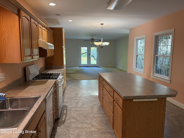 kitchen featuring white appliances, sink, a center island, carpet floors, and hanging light fixtures