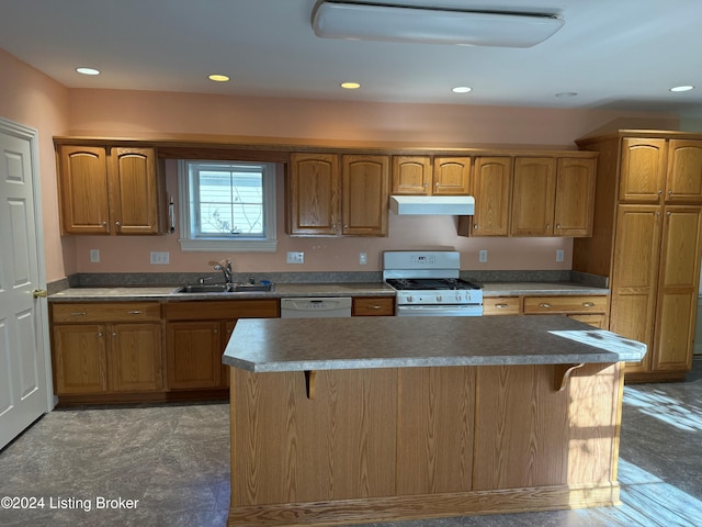 kitchen featuring white appliances, sink, a breakfast bar area, and a kitchen island