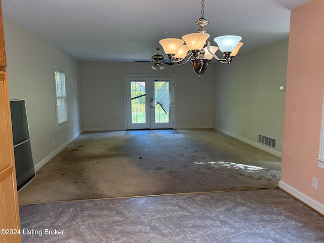 empty room with carpet, ceiling fan with notable chandelier, and french doors