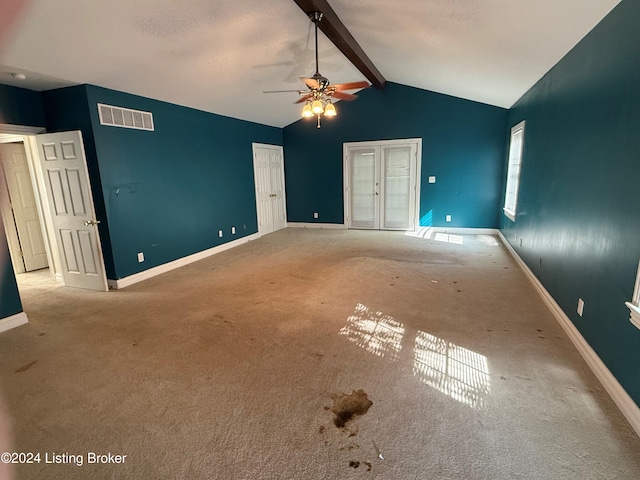 interior space with vaulted ceiling with beams, carpet, and ceiling fan