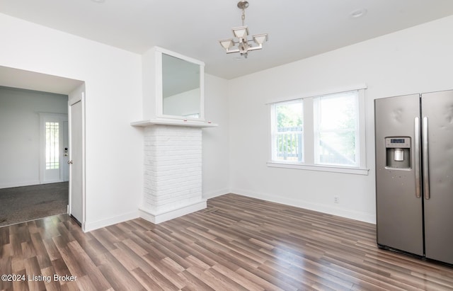 unfurnished dining area with dark wood-type flooring and a chandelier