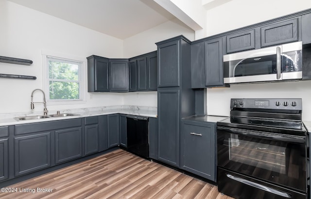 kitchen with black appliances, sink, and hardwood / wood-style flooring