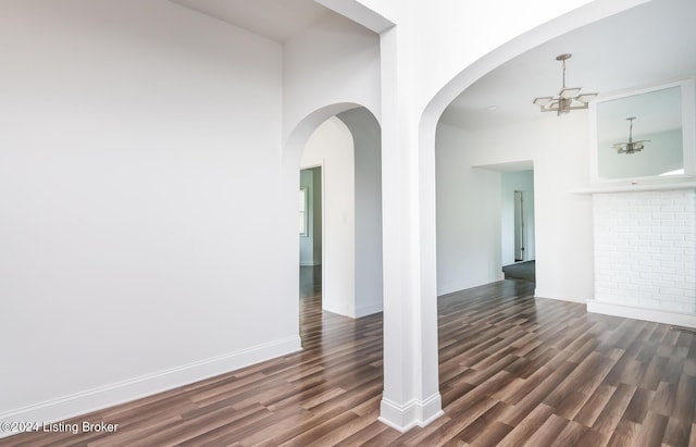 spare room featuring a chandelier and dark hardwood / wood-style floors