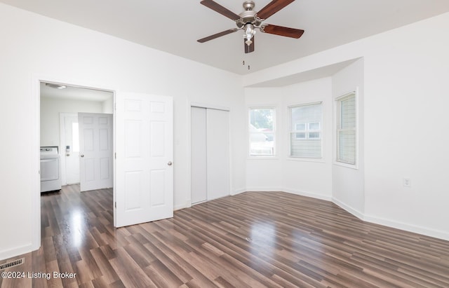 unfurnished bedroom featuring ceiling fan, dark hardwood / wood-style flooring, washer / clothes dryer, and a closet