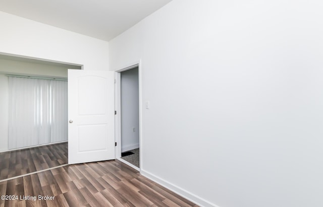 unfurnished bedroom with dark hardwood / wood-style flooring and a closet