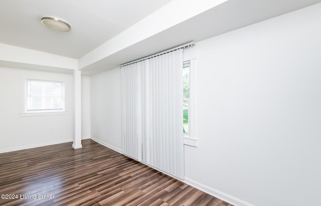 unfurnished room featuring dark hardwood / wood-style flooring and a healthy amount of sunlight