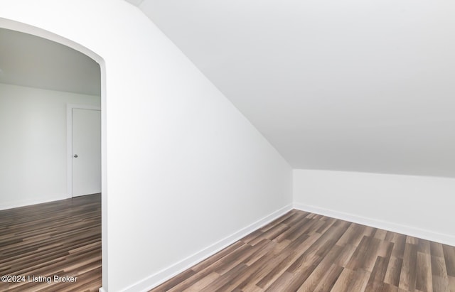 bonus room with lofted ceiling and dark wood-type flooring