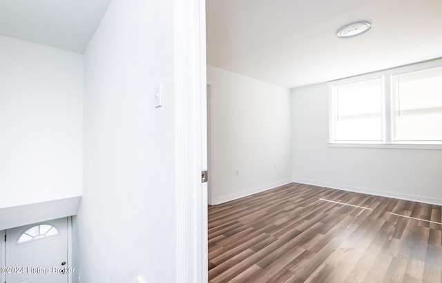 unfurnished room with dark wood-type flooring