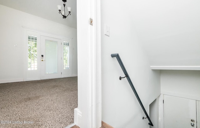 stairway with a notable chandelier and carpet