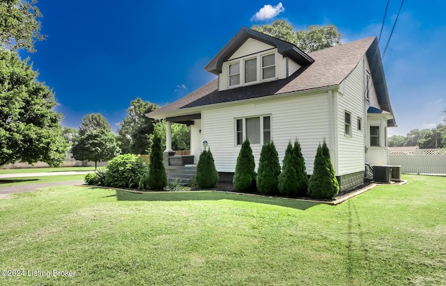 exterior space with a yard, covered porch, and central air condition unit