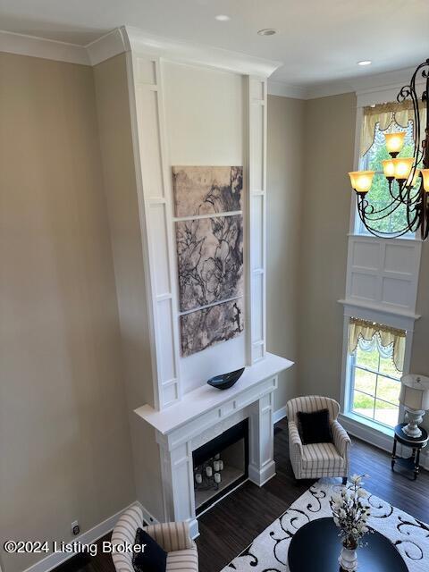 living room with dark hardwood / wood-style floors, crown molding, and a notable chandelier