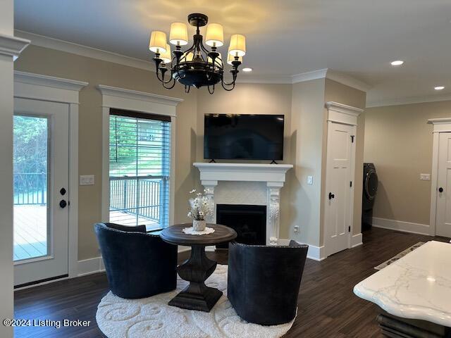 living room with a healthy amount of sunlight, dark hardwood / wood-style flooring, a chandelier, and ornamental molding