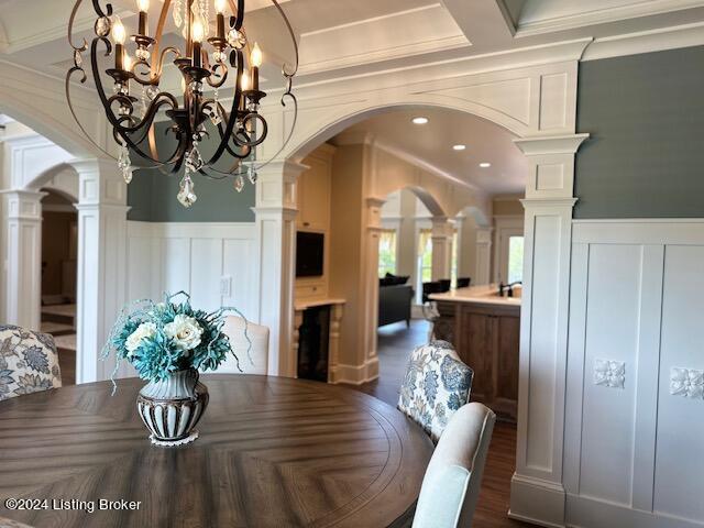 dining space with ornate columns, beamed ceiling, a chandelier, crown molding, and coffered ceiling