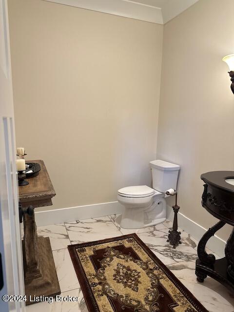 bathroom with toilet and crown molding