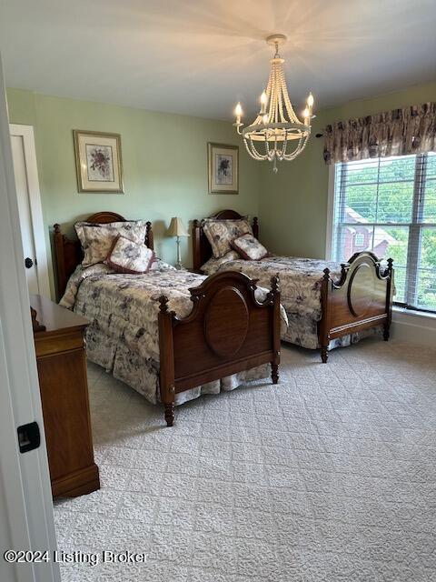 carpeted bedroom featuring a chandelier