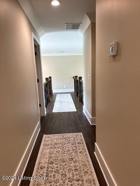 hallway featuring dark hardwood / wood-style flooring and crown molding