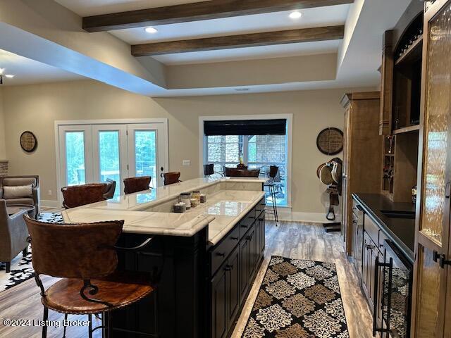 kitchen featuring light wood-type flooring, sink, a kitchen bar, and a center island