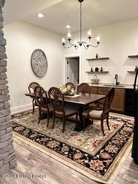 dining space featuring a notable chandelier, sink, and light hardwood / wood-style floors