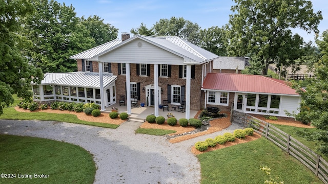 view of front of house with a front lawn, a patio area, and a sunroom